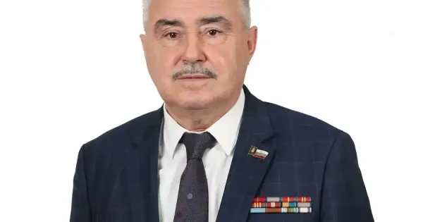 Мужчина в деловом костюме на трибуне с микрофоном